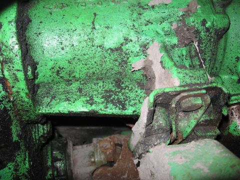 1979 Ford F-150 - Close-up of a heavily soiled green engine block with visible mechanical components and signs of wear.