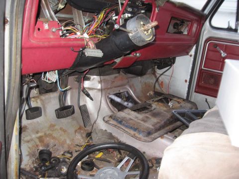 1979 Ford F-150 - The interior of a 1979 Ford F-150 shows extensive exposed wiring and a red dashboard, indicating a project or repair in progress.