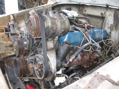 1979 Ford F-150 - Close-up view of an engine bay, focusing on the V-belt system and AC compressor.