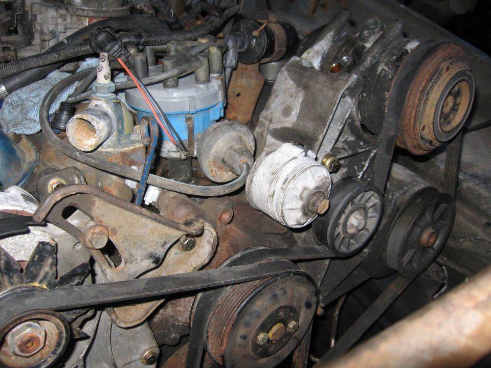 Engine pulleys, belts, and distributor cap with blue housing