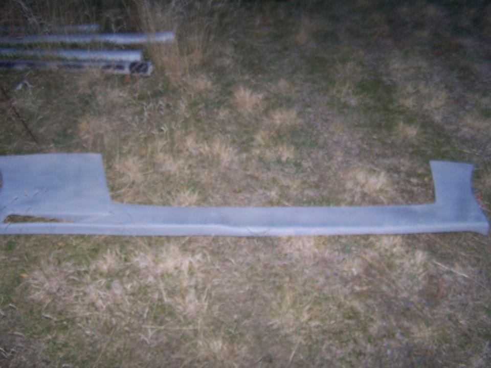 Car side skirt part lying on grass
