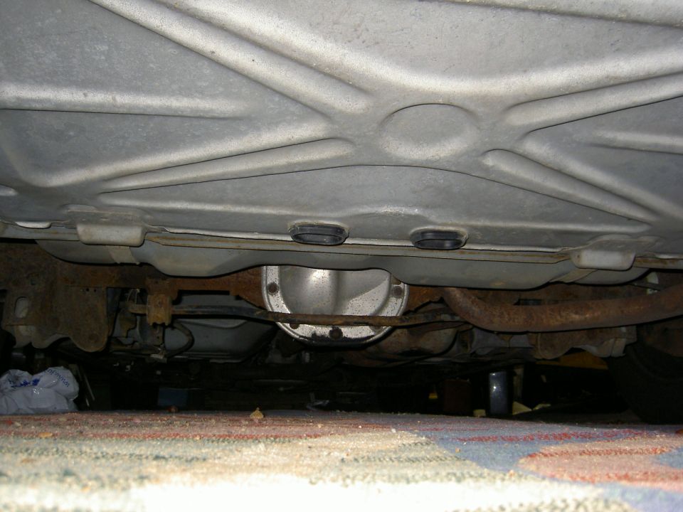 Underside of a vehicle showing transmission pan and floor pan from below