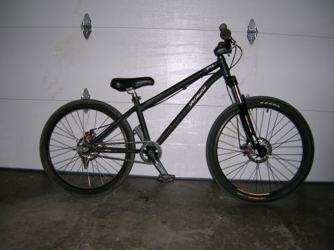 1997 Ford Probe - A black Specialized bicycle is shown from the side, leaning against a garage door.