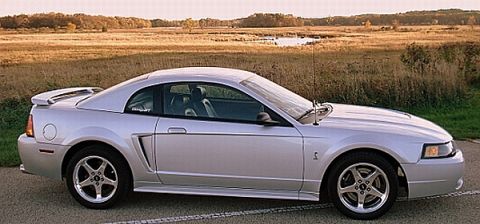 1998 Ford Taurus - Silver coupe with a spoiler and side scoop parked outdoors.
