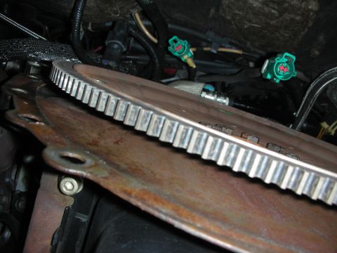 1992 Ford Crown Victoria - Close-up of a vehicle's engine bay, focusing on a flywheel and surrounding wiring.