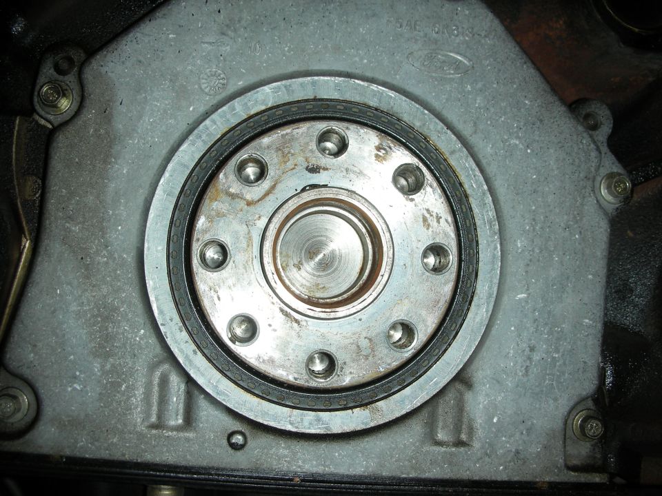 Close-up of engine crankshaft seal housing with Ford logo visible