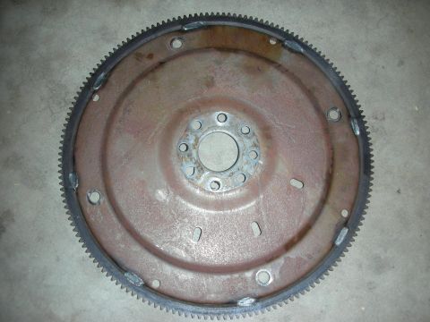 1992 Ford Crown Victoria - A rusty flywheel, a component of a vehicle's transmission, is shown against a concrete background.