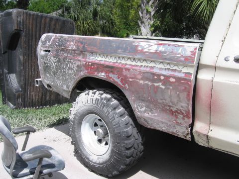 1979 Ford F-150 - The rear quarter panel of a 1979 Ford F-150 shows extensive bodywork and primer.
