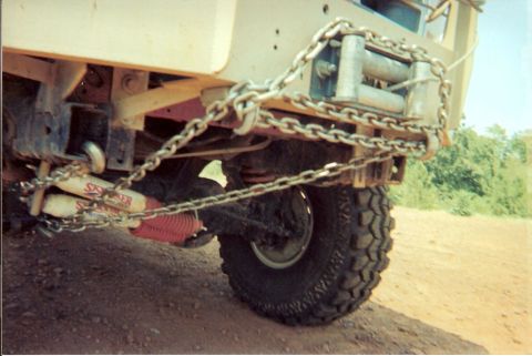 1995 Ford Bronco - Vehicle rear end shows a winch and heavy chains, with red shock absorbers visible.