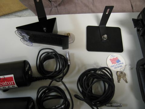 1991 Ford LTD Crown Victoria - Various components of a radar detection system are laid out, including the main unit, power cables, and mounting hardware.