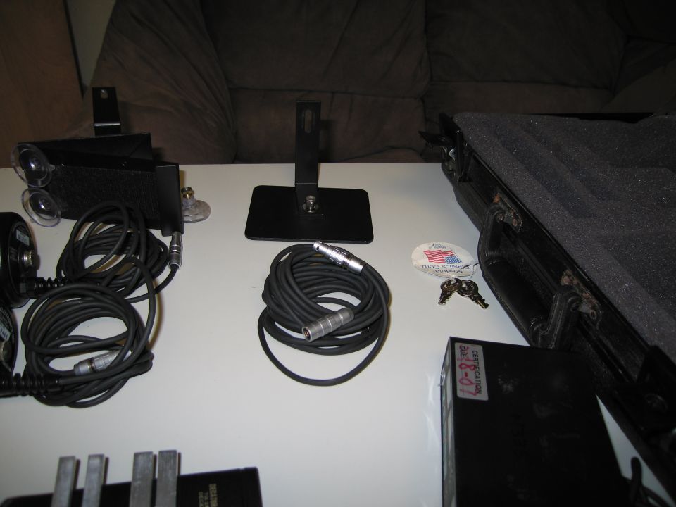 Audio cables, microphone stands, and a black equipment case on a white table