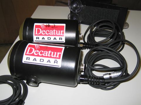 1991 Ford LTD Crown Victoria - Two black Decatur radar units are shown with coiled cables and a suction-cup mounted device.