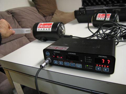 1991 Ford LTD Crown Victoria - A hand holds a calibration tool near a Decatur radar unit next to a Genesis II control box.