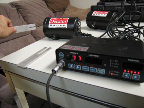 1991 Ford LTD Crown Victoria - A radar gun and tuning forks are laid out on a table, with "Decatur RADAR" branding visible on the equipment.