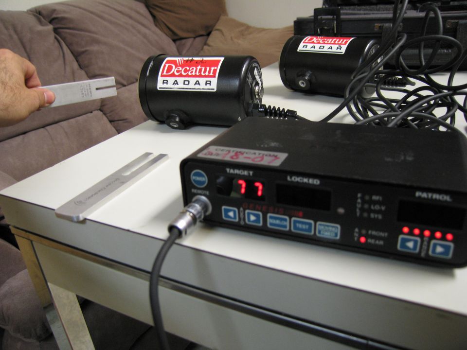 Radar gun with "Decatur RADAR" labels and tuning forks on a table