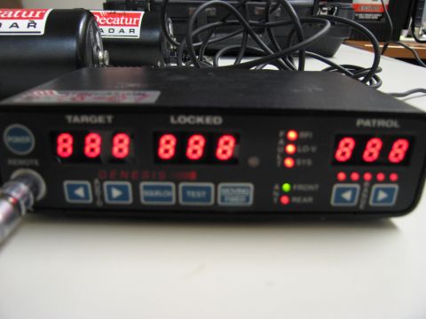 1991 Ford LTD Crown Victoria - A radar detector unit, labeled 'GENESIS PRO', displays speed readings and status lights, with 'Decatur RADAR' units visible in the backgrou…