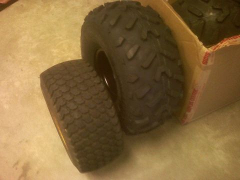 2001 Ford F-150 - Two lawnmower tires are shown, one with a knobby tread and the other with a smoother pattern, placed beside an open cardboard box.