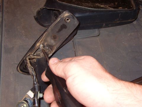 1983 Ford Bronco - Remove the T-10 stainless screw that retains the mirror gasket.