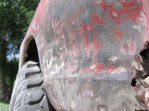 1979 Ford F-150 - This truck body shows extensive bodywork with primer and sanding marks, revealing its underlying structure and a large tire.