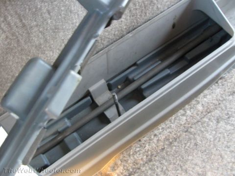 1994 Chevrolet Silverado 3500 - Close-up of a gray molded plastic component with a recessed channel of parallel ridges and a diagonal metal rod, resting on gray carpet wit…