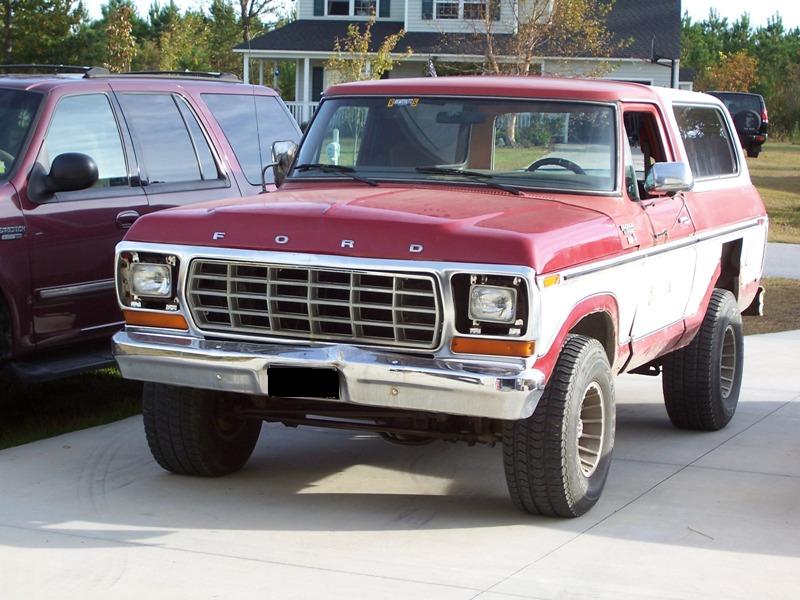 1978 Ford Bronco front view, parked next to a dark SUV