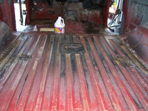 1978 Ford Bronco - The interior floor of a vehicle is shown with its components removed, revealing the ribbed metal floor and a cleaning supply.