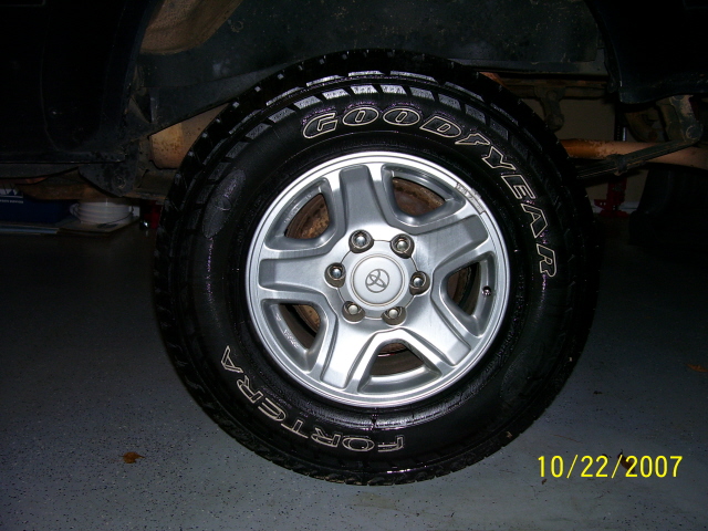 Close-up of a Goodyear Fortera tire on a silver 5-spoke wheel with a Toyota logo