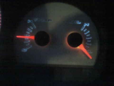 2001 Ford Crown Victoria - The vehicle's dashboard gauges are illuminated, showing fuel and possibly speed or RPM levels.
