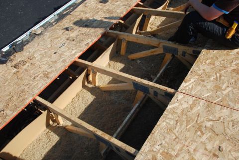 1996 Ford Bronco - Construction workers are visible on a roof undergoing repair, with exposed framing and plywood.