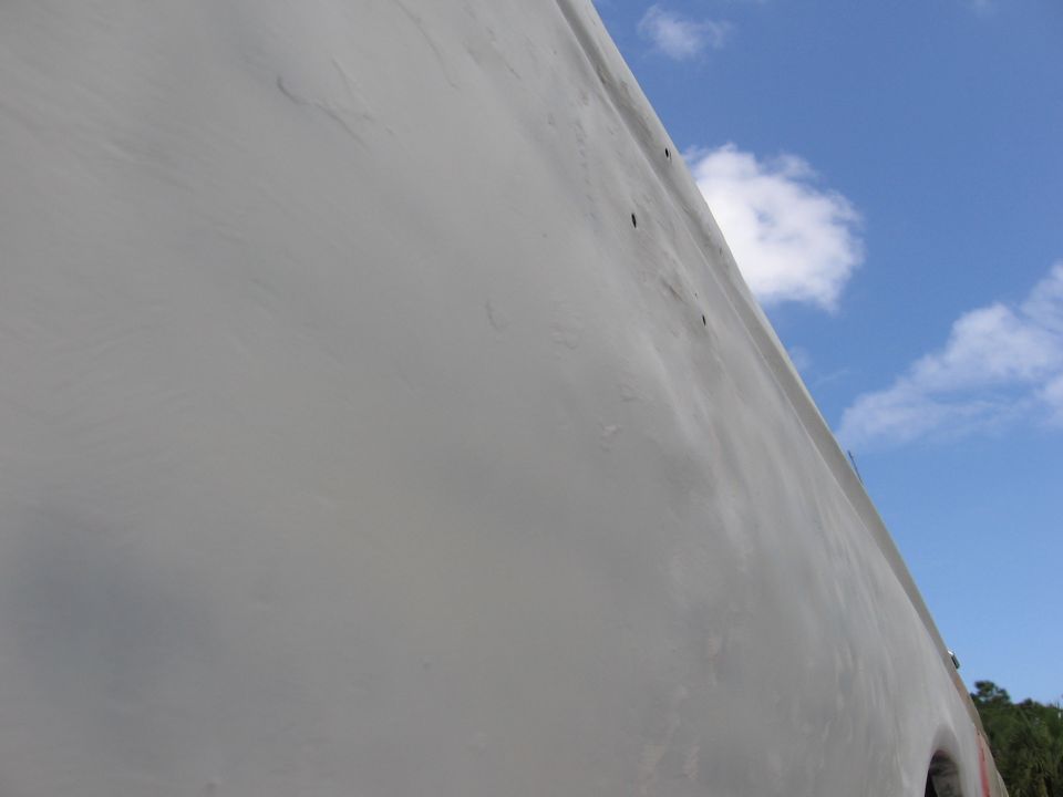 Gray vehicle side panel against blue sky