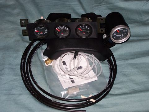 1995 Ford Probe - A car gauge pod assembly with multiple gauges and associated tubing is laid out on a textured surface.
