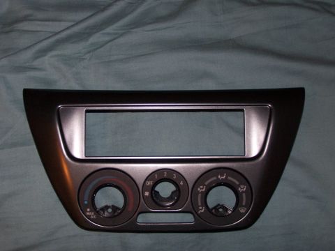 1995 Ford Probe - Dashboard trim piece with radio opening and climate controls, likely for an aftermarket stereo installation.
