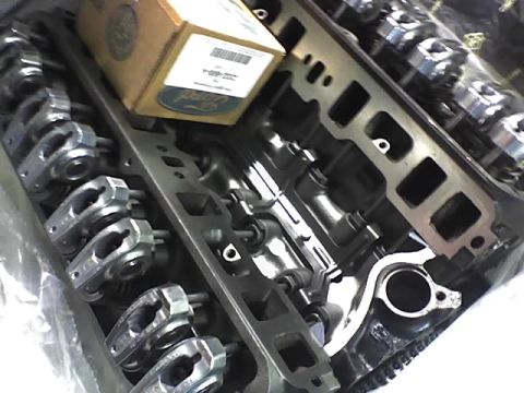 1991 Ford Mustang - Close-up view of engine components, including an intake manifold and rocker arms, with a box bearing Ford branding visible.