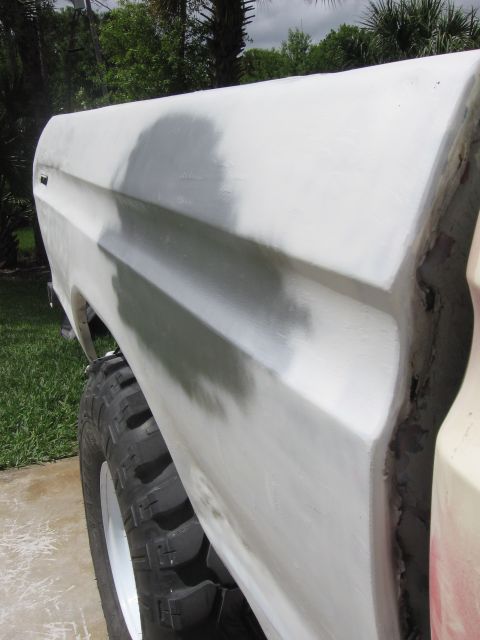 1979 Ford F-150 - Side view of a 1979 Ford F-150 fender undergoing body work, with a large tire visible.