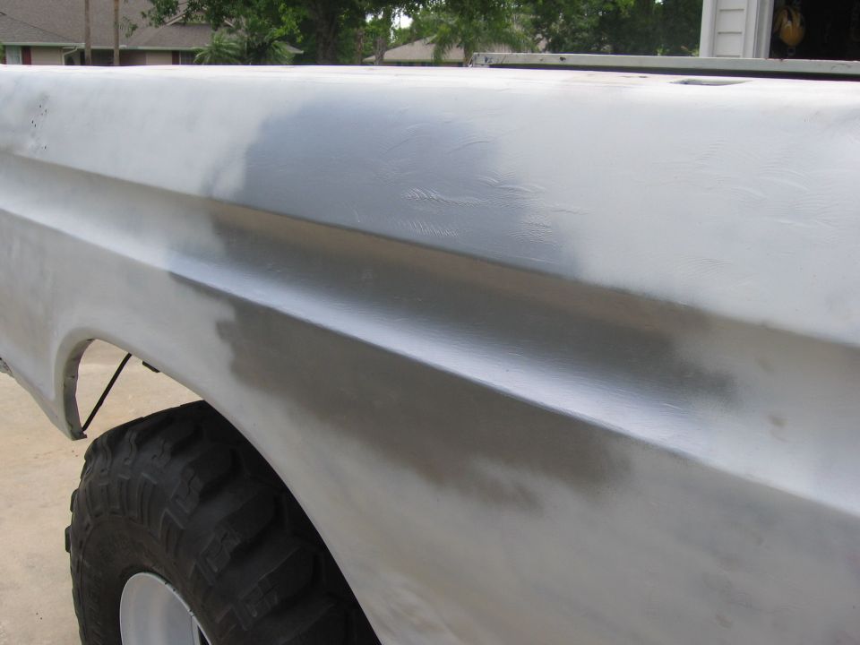 1979 Ford F-150 bed side panel with primer, showing bodywork in progress