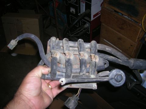 1985 Ford Bronco - Fuel injector rail assembly with hoses and electrical connectors, held by a hand.