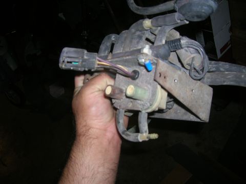 1985 Ford Bronco - A hand holds a fuel pump assembly, a component of a vehicle's fuel system.