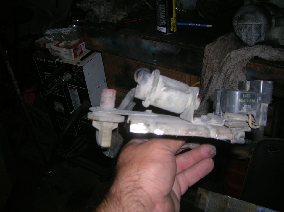 Automotive part with E4TF 9047-F3A markings held by a hand