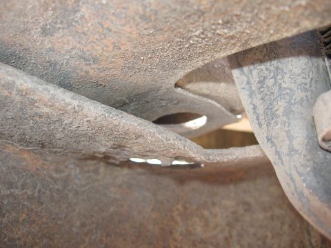 1979 Ford F-150 - Close-up view of heavily rusted frame components on a 1979 Ford F-150, with visible holes in a bracket.