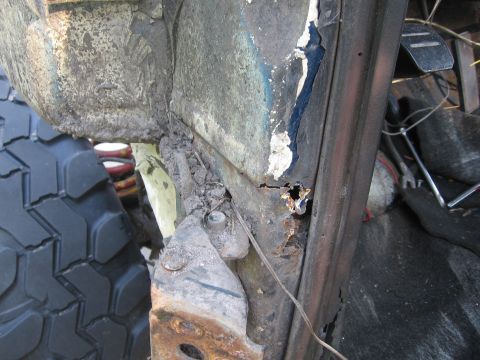 1979 Ford F-150 - Detail shot of heavily rusted vehicle frame and tire, showing interior components.