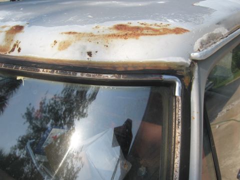 1979 Ford F-150 - Close-up view of the weathered roofline and windshield trim on a 1979 Ford F-150, showing signs of rust and age.
