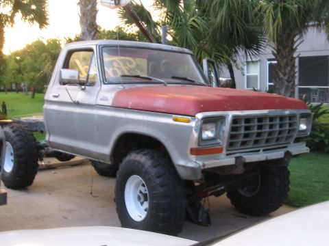 1979 Ford F-150 - This 1979 Ford F-150 pickup truck is shown with a red hood and oversized tires, missing its rear bed.