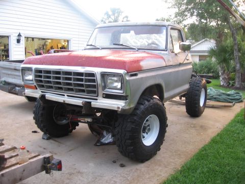 1979 Ford F-150 - This Ford F-150 pickup truck is parked outside a garage with its hood up and large tires installed.