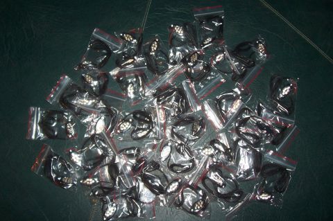 1994 Ford F-150 - Numerous black car emblems are displayed in individual plastic bags, ready for distribution or sale.