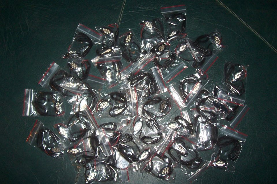 Pile of black car emblems in plastic bags