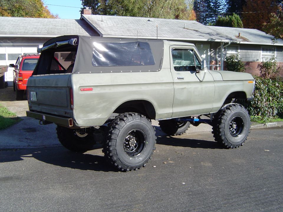 Lifted green soft-top SUV parked on a residential street