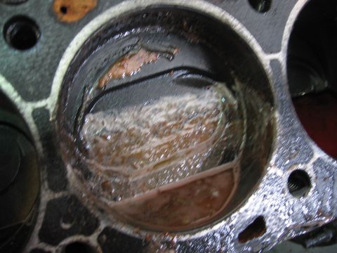 1979 Ford F-150 - Close-up view of a damaged engine cylinder, showing significant internal debris and rust.