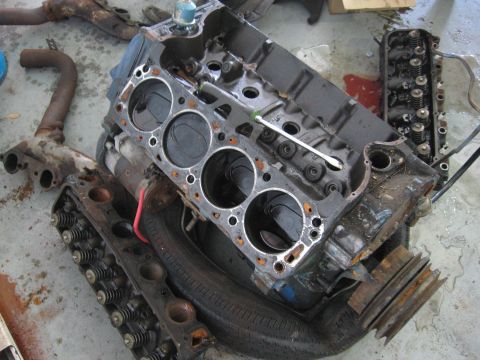 1979 Ford F-150 - Engine components, including a V8 block and cylinder heads, are disassembled and laid out on a concrete surface.