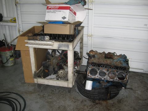 1979 Ford F-150 - Engine block and various parts are stored in a garage setting.