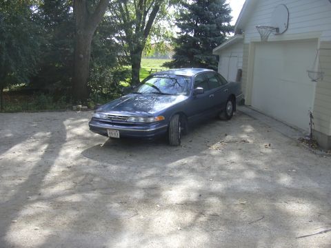 1996 Ford Crown Victoria - This sedan is parked in a driveway with a garage and basketball hoop in the background.